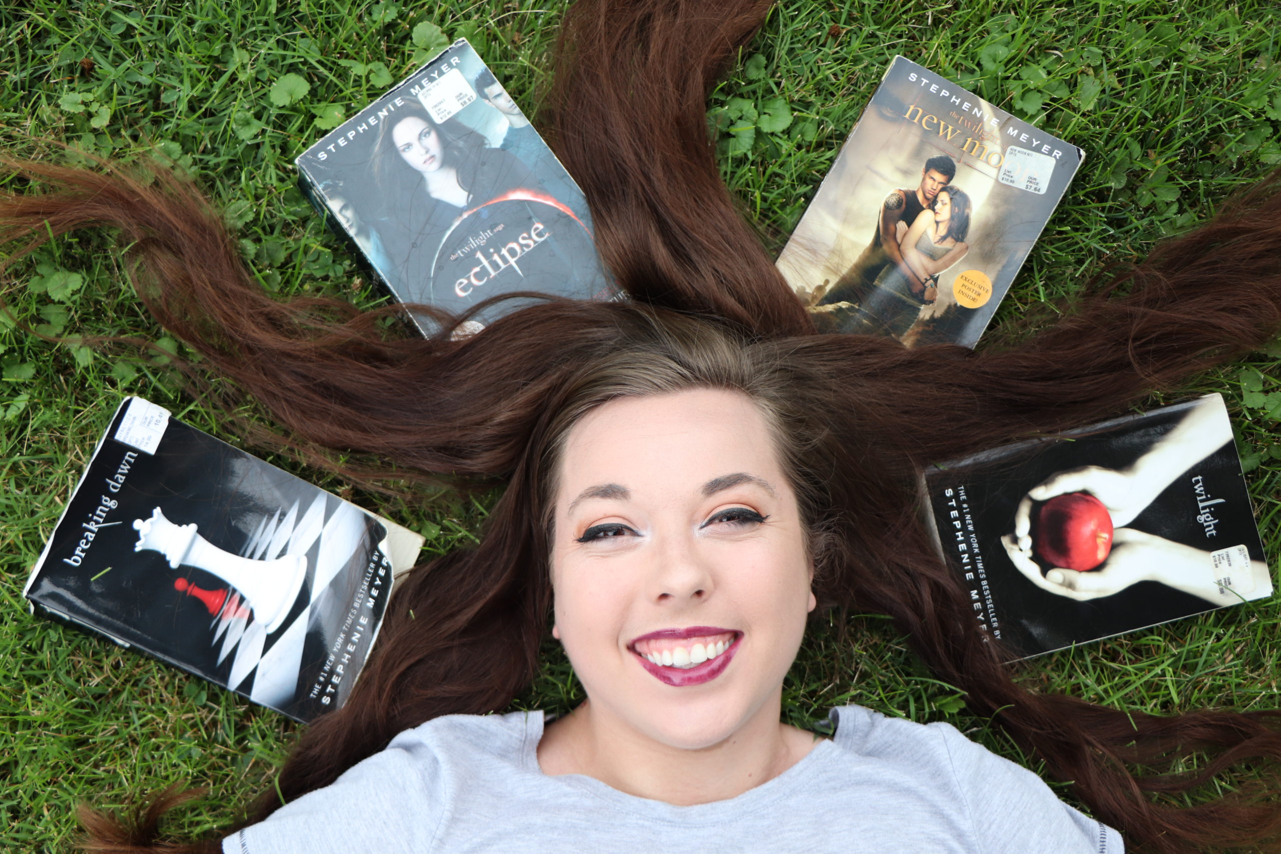 Jessica Ping-Wild laying in the grass with her hair fanned out and the twilight books surrounding her head.